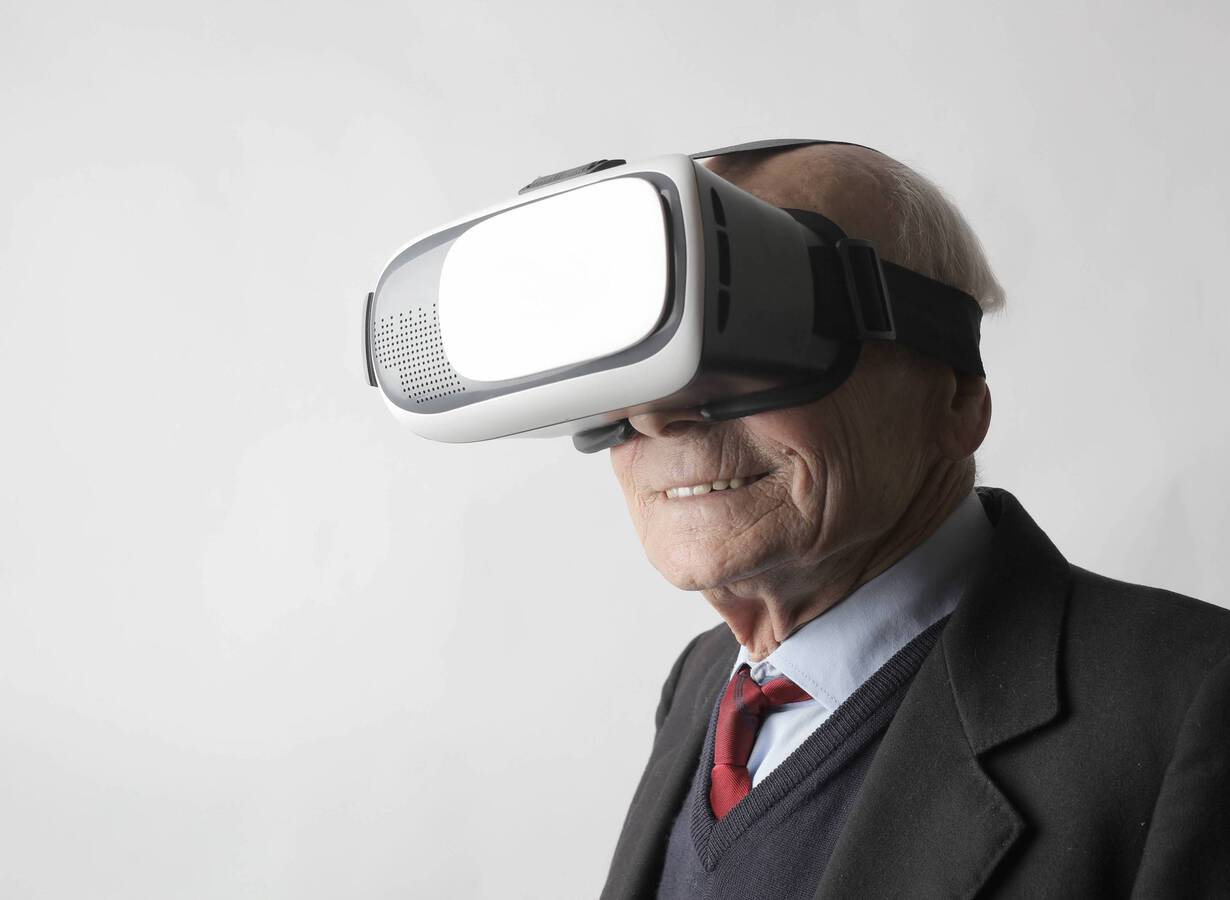 Senior man using vr goggles in studio